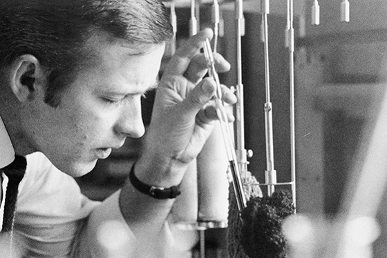 Black and white photo from the 50's. A concentrated man doing tests in the laboratory.